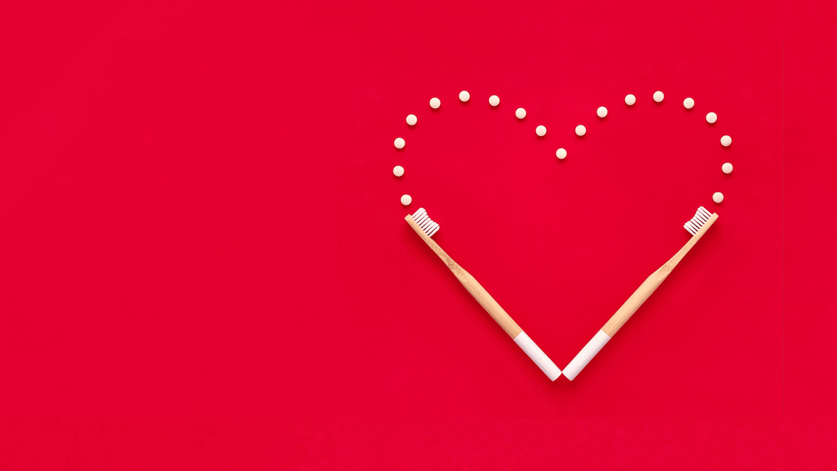 Creative heart shape on the red background with 2 Ecopify Bamboo Toothbrush and toothpaste